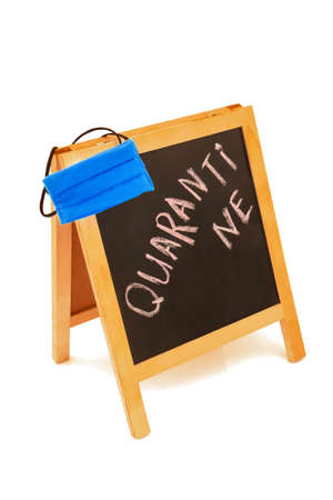 Coronavirus concept with text quarantine, announcement on wooden board, blackboard, chalkboard, frame and blue protective medicine hygienic equipment mask. Isolated on white background.の写真素材