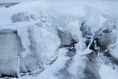 beautiful winter landscape. Snow-covered ice blocks of stones in close-up. stones, icicles, ice, freezing. The harsh far north. Beyond the Arctic Circle.の写真素材