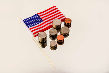 Different American coins in the column and the American flag on the reflecting surface. Top view.の写真素材