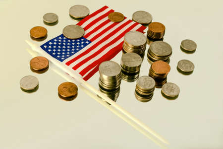 Different American coins in the column and the American flag on the reflecting surface.の写真素材