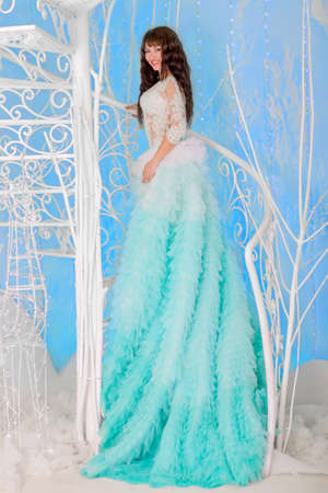 Girl in a magnificent wedding dress, the color of mint. Standing on the beautiful decorative white stair.の写真素材