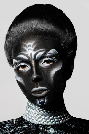 Close-up portrait of a woman with creative make-up. Black leather with white pattern.の写真素材