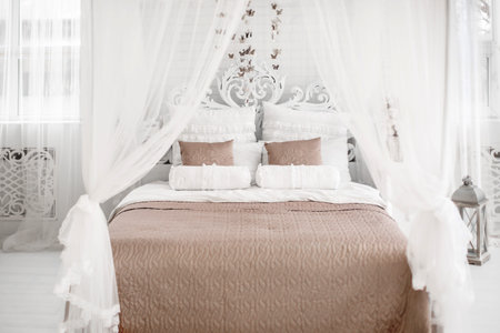 A light bedroom with white bed. Brown linen.の写真素材