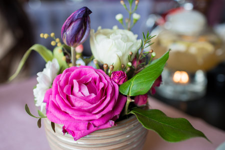 Pink flowers in a vase. A beautiful bouquet in a beige vase on the table. Beautiful design of the...