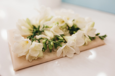 Envelope with white flowers on the table. Preparing for a wedding celebration. Decoration of flowers and decorations for the holiday.の写真素材