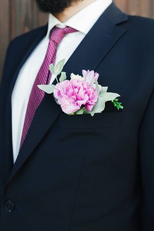 Man in a suit and bow-tie close up. On the jacket - buttonhole, boutonniere. suit of the groom in a blue suit close-up.の写真素材