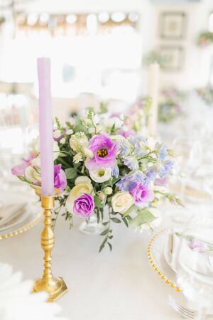Floral wedding decoration. Wedding table setting decorated with fresh flowers. Wedding floristry. Bouquet with roses, eustoma and eucalyptus leaves.の写真素材