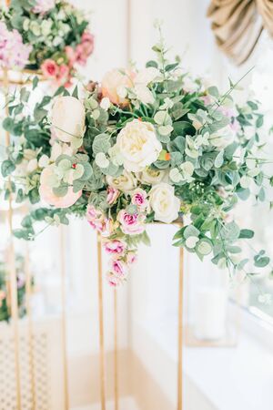 Floral wedding decoration. Wedding table setting decorated with fresh flowers. Wedding floristry. Bouquet with roses, eustoma and eucalyptus leaves.の写真素材