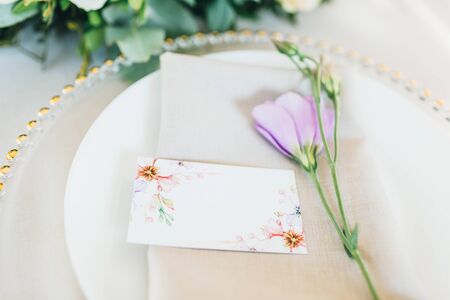Wedding table setting. Transparent plate with fresh flowers.の写真素材