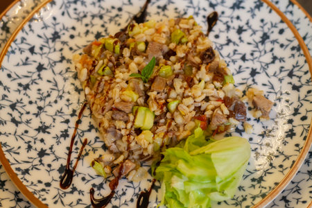 Warm pearl barley salad with meat and zucchini decorated with green lettuce leaves.の写真素材