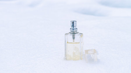 Cool refreshing fragrance of perfume in a glass bottle in the snow.の写真素材