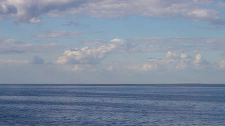 endless blue calm sea or lake with blue sky with white clouds.の写真素材