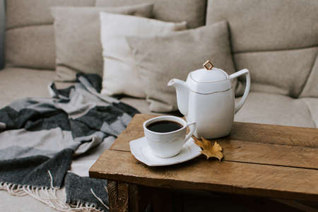 Still life a cup of tea in the living room on a wooden table, the concept of comfort and interior. Cozy autumn or winter concept.の写真素材