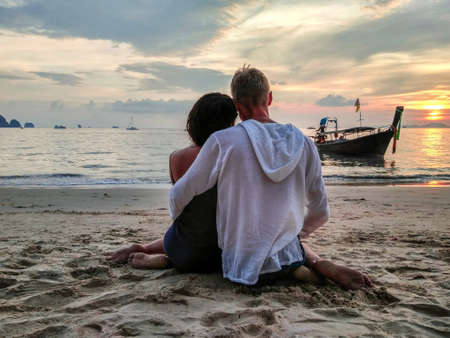 Lovely couple together on the beach, back view.の写真素材
