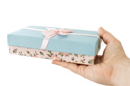 Blue gift box with pink ribbon in hand. Isolated on white