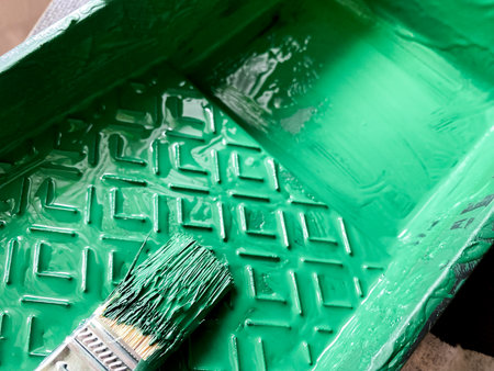 Green paint filling textured tray with paintbrush soaking in vibrant color, ready for diy projects, home improvement or creative art and craft work. Decorative for designの写真素材