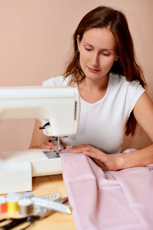 Young attractive woman sewingの写真素材