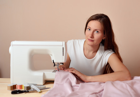 Young attractive woman sewingの写真素材