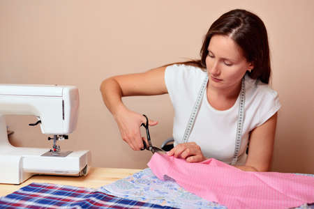 Young attractive woman cutting fabricの写真素材