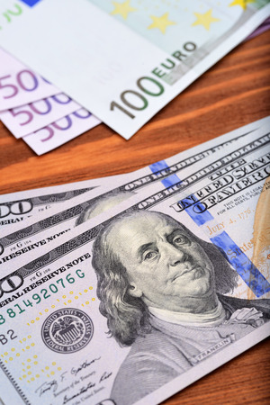 Dollar and euro bank notes on wooden tableの写真素材