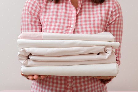 Woman holding a pile of clean ironed linenの写真素材