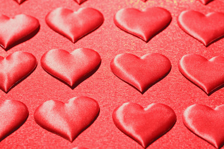 Closeup of a red heart on a shiny red background. The concept of love, choice and celebration of...
