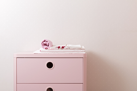 A pile of clean ironed bedding and a towel lies on the dresser.の写真素材