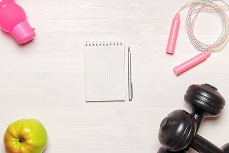 Sports accessories on a white wooden background. Flat layout. Copy space. The concept of a healthy lifestyle.の写真素材