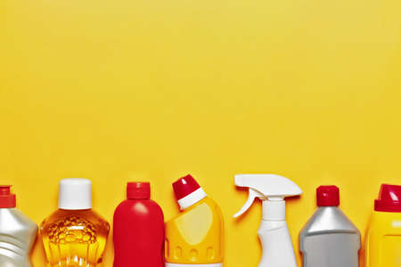 A variety of home cleaning products on a yellow background with copy space, top viewの写真素材
