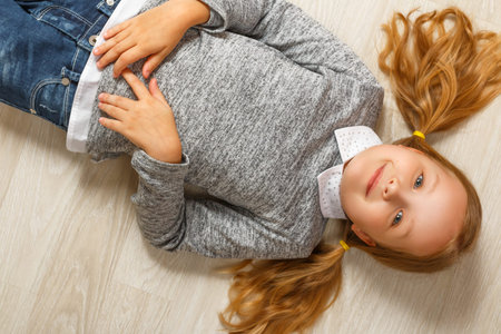 Top view of a little girl lying on the floor