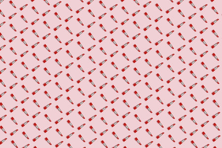 Perpendicular geometric pattern of red lipstick on a pink background.の写真素材