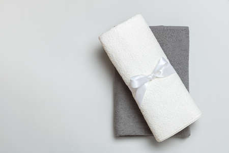 Top view of a stack of rolled up white and gray towels with copy space.の写真素材