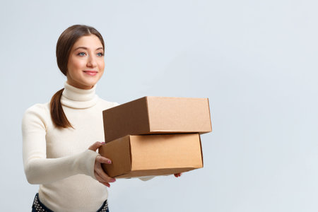 Smiling beautiful girl hands over boxes with orders. Young woman with purchases. delivery