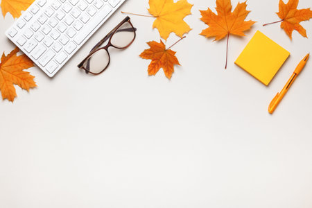 Desktop keyboard glasses note paper with autumn maple leaves. Top view flat lay copy spaceの写真素材
