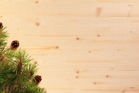 New year and christmas celebration concept. Spruce branch with cones on a wooden background.の写真素材