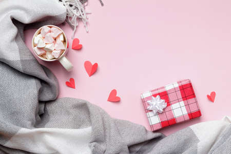 Gray plaid cup marshmallows gift paper hearts on pink background. Valentine's day. Flat lay top view copy space.の写真素材