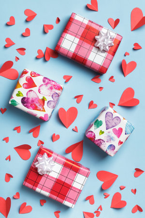 Red paper hearts and boxes with gifts on a blue background. Mother valentine's day greeting card invitations. Top view flat layの写真素材