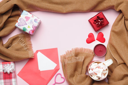 Composition for Valentine's Day. Letter of beige cashmere scarf cup marshmallow gifts candle on pink background.の写真素材