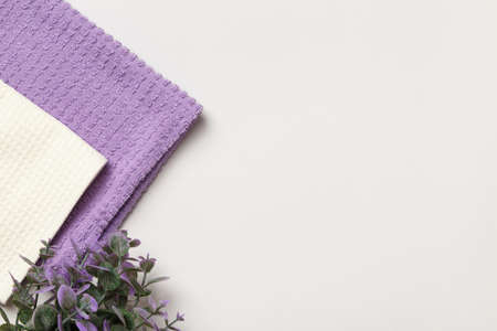 Purple and white waffle towels, floral plant on gray background with copy space and place for text.の写真素材