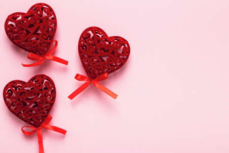 Three red valentine hearts on a pink background with copy space.の写真素材