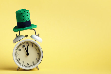 St. Patrick's Day celebration concept. Alarm clock in a green hat on a yellow background.の写真素材