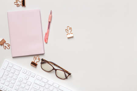 Work table top view. Notepad keyboard glasses paper clip on the desk. Flat lay copy spaceの写真素材