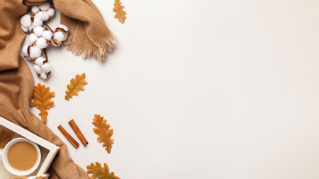 Autumn concept of comfort. Cashmere scarf, a cup of coffee with autumn oak leaves on a gray background.の写真素材