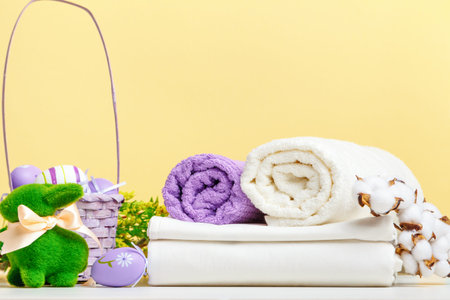 Towel rolls white bed linen with easter decor on the tableの写真素材