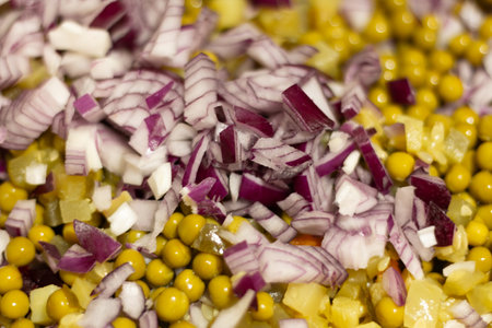 Colorful chopped vegetables, including red onion and mustard seeds, prepared for a festive meal.の写真素材