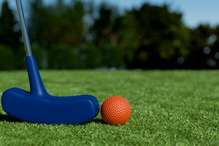 A closeup of a blue putter and an orange golf ball on a sunny green lawn. 3d renderingの写真素材