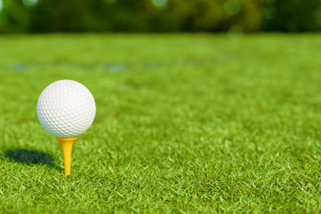 A golf ball on a tee, ready for play on a sunny day. 3d renderingの写真素材