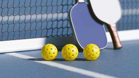 Three yellow pickleballs balls and a paddles on a court, ready for a game. 3d renderingの写真素材