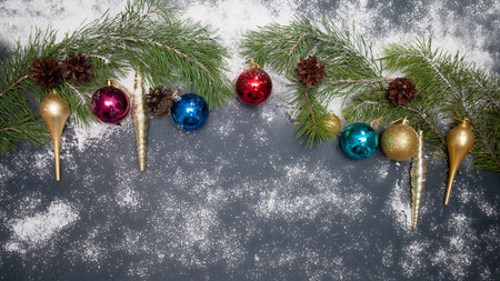 Christmas background with snowfall, a composition of spruce, a frame of multicoloredornaments and a...