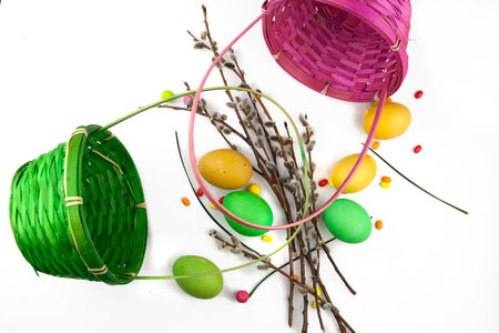 Easter background, colorful easter eggs and decorations next to baskets and pussy willow branches